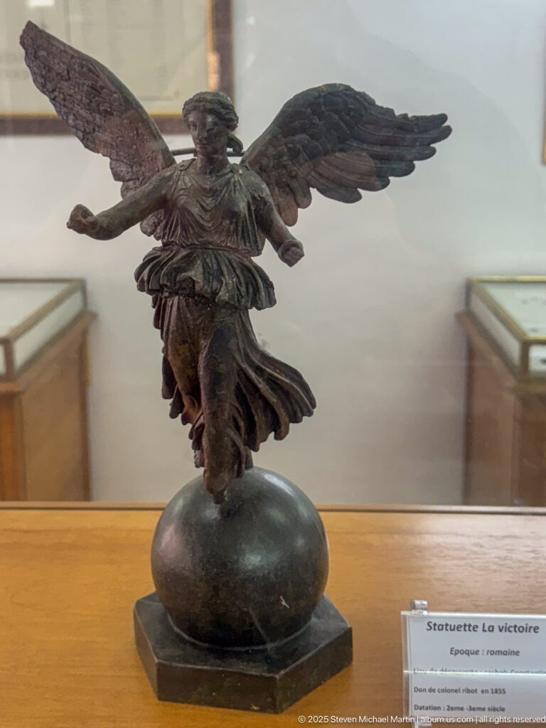 Bronze La Victoire de Constantine, a winged female Victory poised on a globe with outstretched wings and flowing drapery.