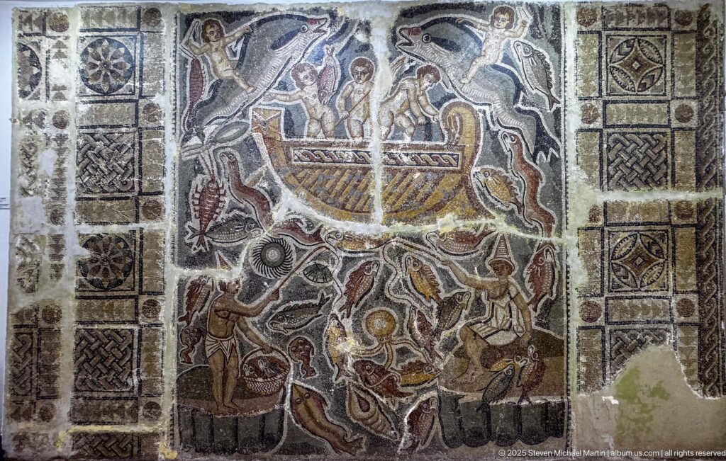 Large ancient mosaic with a central boat-like form, multiple human and animal figures, and geometric border panels.