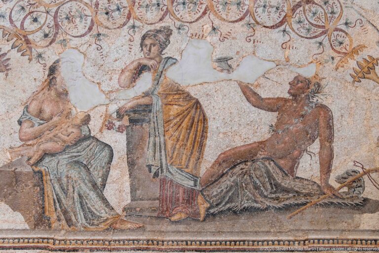 Detail of the Djemila Bacchus Mosaic with a seated woman, standing draped woman, and reclining male figure.