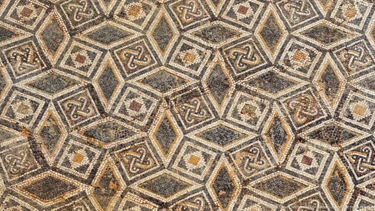 Close Roman mosaic detail with interlocking octagons, small squares, knot motifs, and dark geometric outlines.