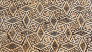 Close Roman mosaic detail with interlocking octagons, small squares, knot motifs, and dark geometric outlines.