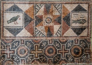 Roman mosaic detail with a bird, an eight-pointed star, a fish-like motif, and circular geometric designs.