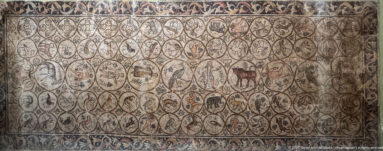 Roman mosaic of curling vine compartments filled with birds, quadrupeds, and other small animals.