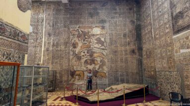 Djemila Museum gallery with the Great Hunt Mosaic from the House of Bacchus centered above a visitor.