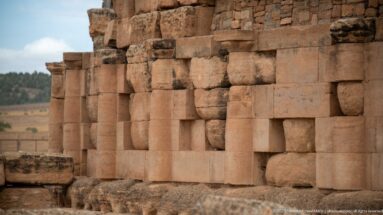Close side view of engaged cylindrical columns alternating with large dressed stone blocks on the Medracen’s lower circular wall.