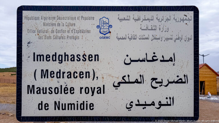 Multilingual French and Arabic sign reading Imedghassen (Medracen), Mausolée royal de Numidie, with Algerian heritage agency markings.