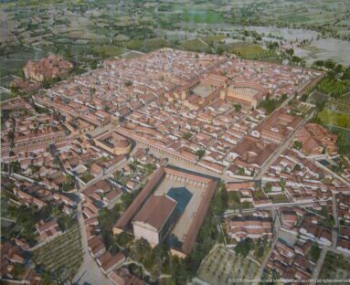 Aerial reconstruction model of Timgad with red-roofed buildings, straight streets, and large public complexes.