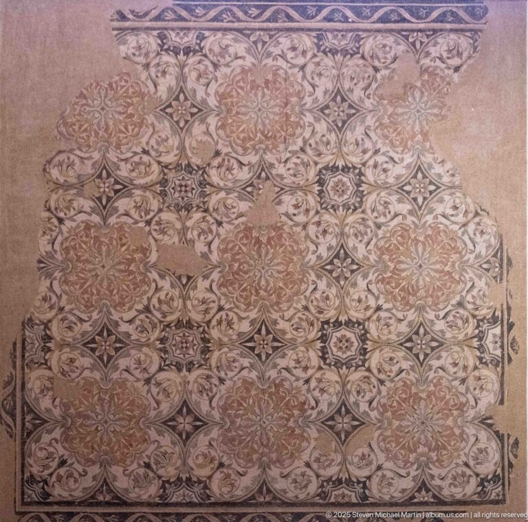 Polychrome Roman mosaic with repeating floral rosettes, star-like motifs, and fragmentary edges.