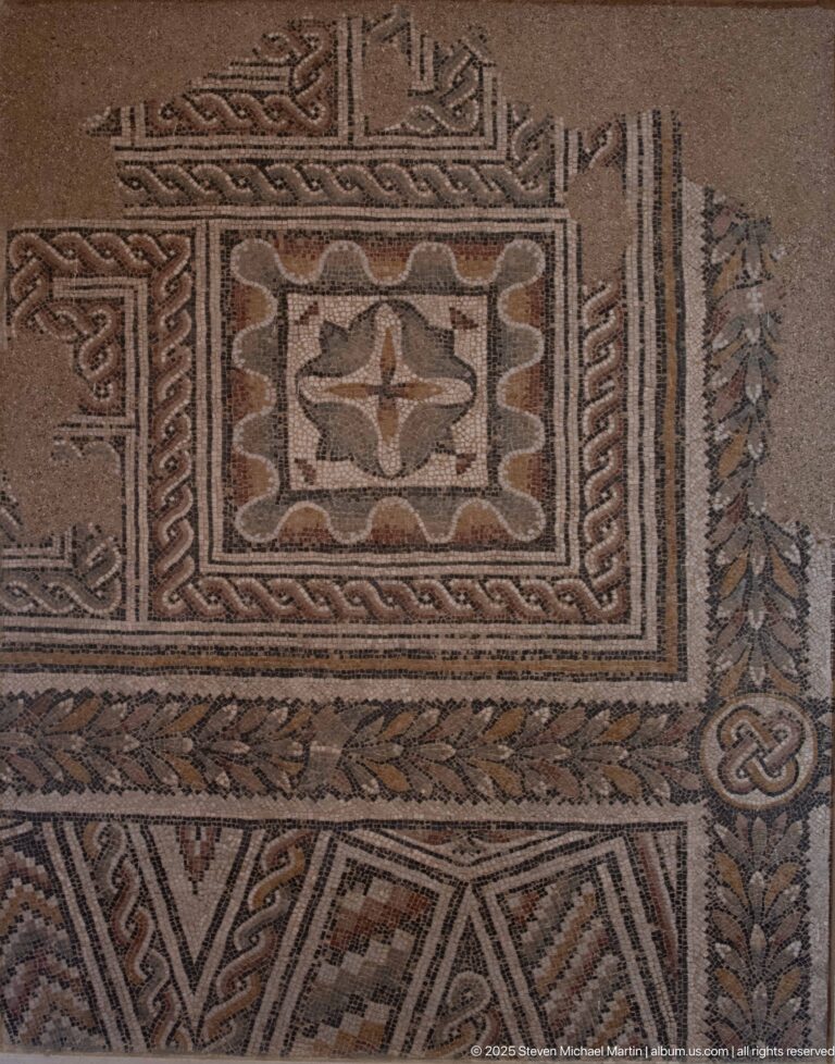 Close-up of a Roman mosaic with nested rectangular frames, checker patterns, braids, and knot-like geometric motifs.