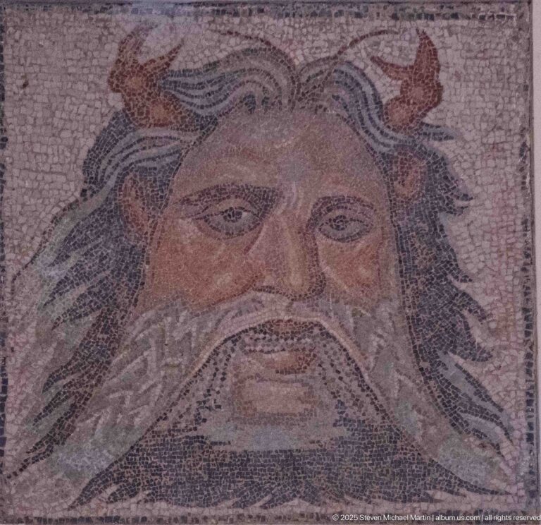 Monumental mosaic head of Oceanus with flowing beard and red crustacean claws projecting from his temples.