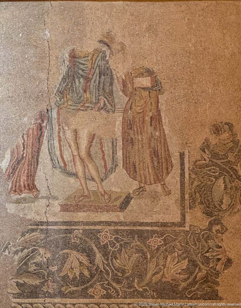 Fragmentary Roman mosaic showing a horse, several standing figures, and ornate vegetal borders.