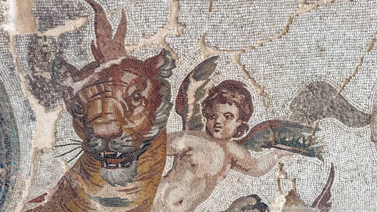 Roman mosaic detail of a winged youth beside the head of a large striped feline.