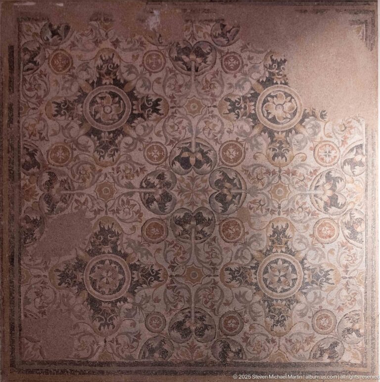 Large Roman mosaic pavement with repeating floral medallions and dense scrolling ornament.
