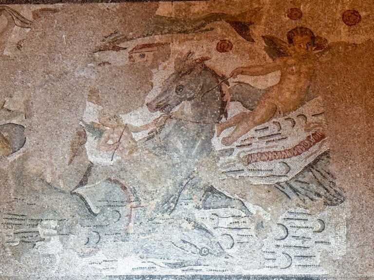 Fragmentary Roman mosaic with partial human and animal figures separated by large areas of missing tesserae.