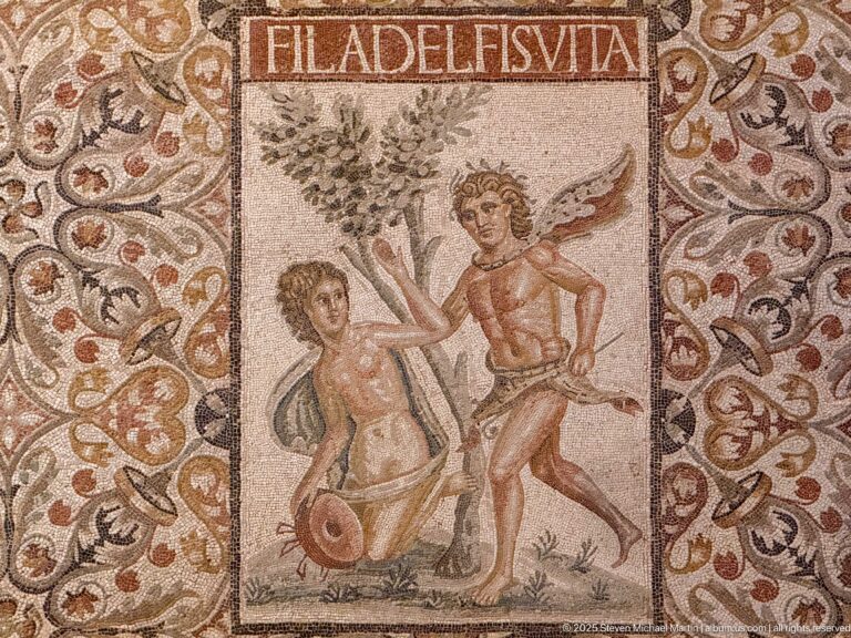 Zeus disguised as a satyr pursuing Antiope as a Maenad beneath the FILADELFIS VITA inscription in the Mosaic of the Philadelphi.