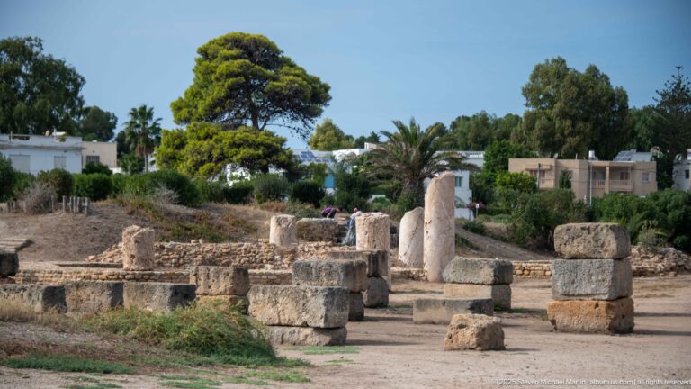 Low ancient masonry, column drums, and upright stone fragments beside the Punic Ports in Carthage.
