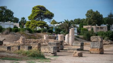 Low ancient masonry, column drums, and upright stone fragments beside the Punic Ports in Carthage.