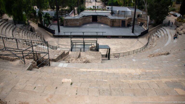 High view down the Roman Theatre of Carthage seating toward the modern stage and performance area.