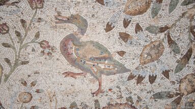 Roman mosaic of a peacock among flowers, leaves, fruit, and smaller birds.