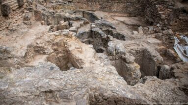 Rectangular rock-cut burial shafts and surrounding masonry in the Phoenician necropolis at Carthage.