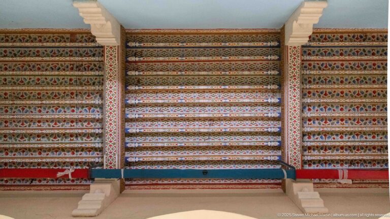 Broad interior panels covered with dense horizontal bands of red, blue, cream, green, and gold geometric ornament.