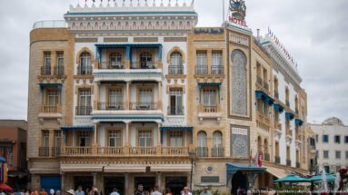 Ornate Hotel Royal Victoria façade with balconies, blue trim, arched windows, and a large vertical tile panel.