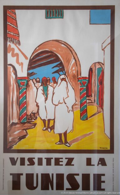 Vintage French tourism poster reading Visitez la Tunisie with robed figures gathered beneath a large arch.