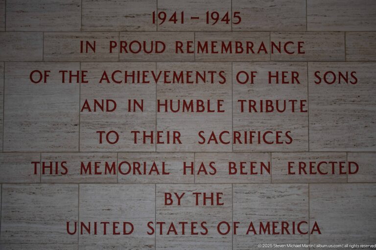 English 1941–1945 dedication in red letters on pale stone honoring achievements and sacrifices of American servicemen.