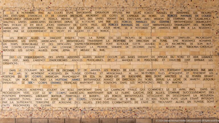 Large tan mosaic text panel filled with French paragraphs describing World War II operations.