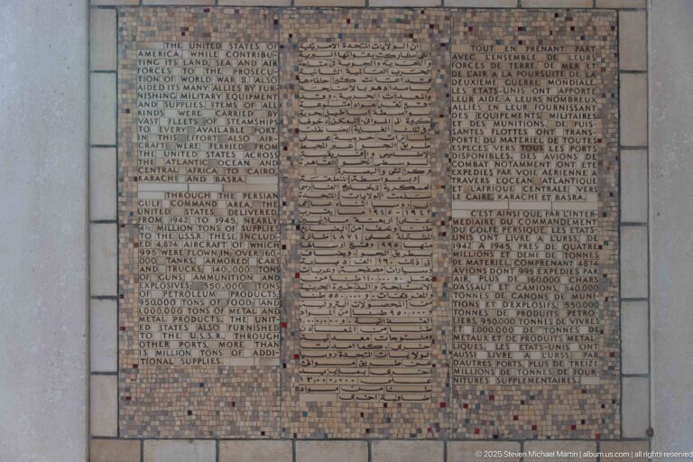 Memorial panel with Arabic text in the center and dense French text columns on both sides.