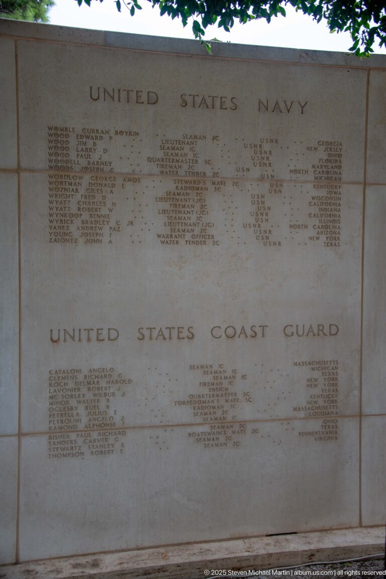 Stone memorial panels engraved with names beneath United States Navy and United States Coast Guard headings.