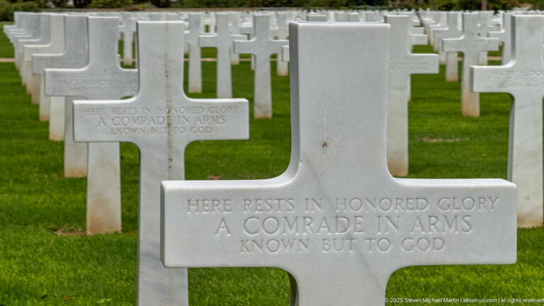 Close white cross for an unknown service member, with another matching Known But to God marker behind.