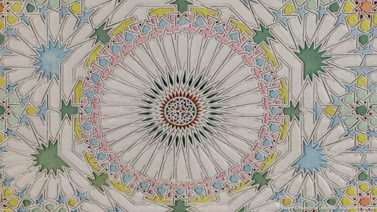Radial white ceiling medallion surrounded by pink, yellow, green, blue, and turquoise geometric star patterns.