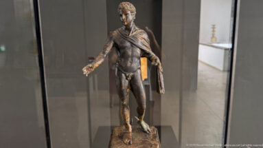 Bronze statuette of Hermes from the Mahdia shipwreck, standing nude with right hand extended and drapery falling from his left shoulder.
