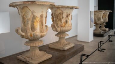 Monumental marble kraters from the Mahdia shipwreck with Dionysiac figural reliefs, scrolling handles, and tall pedestal bases.