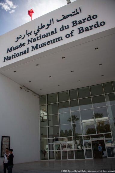 Arabic, French, and English National Bardo Museum lettering above a glass entrance façade.