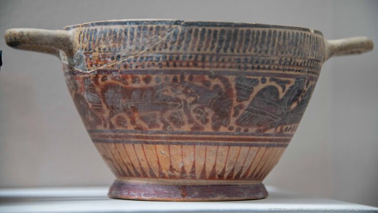 Painted ceramic bowl with a side handle, geometric bands, and a central frieze of stylized animals.