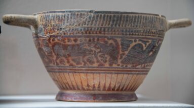 Painted ceramic bowl with a side handle, geometric bands, and a central frieze of stylized animals.