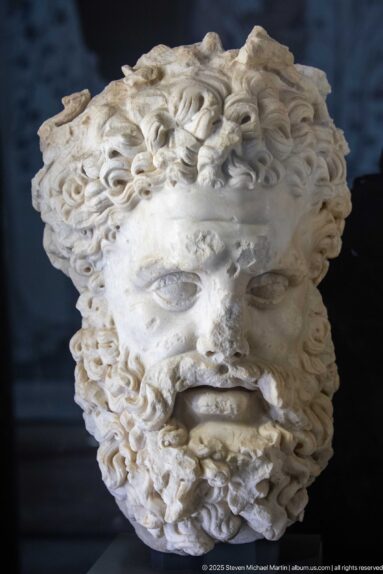 Larger-than-life marble portrait head of Roman emperor Lucius Verus from Dougga, with deeply drilled curling hair and beard.