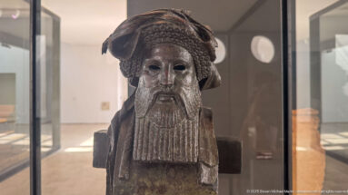 Bronze herm of bearded Dionysos from the Mahdia shipwreck, with elaborate wrapped headdress, long segmented beard, and squared pillar body.