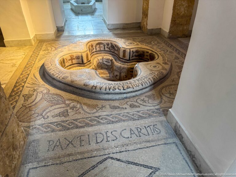 Four-lobed mosaic baptismal font from Demna with Christian inscriptions and symbols across the basin and surrounding pavement.