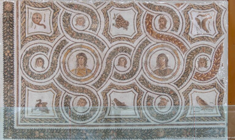 Roman mosaic with female portrait medallions, birds, star-shaped compartments, wreaths, and interlaced decorative borders.