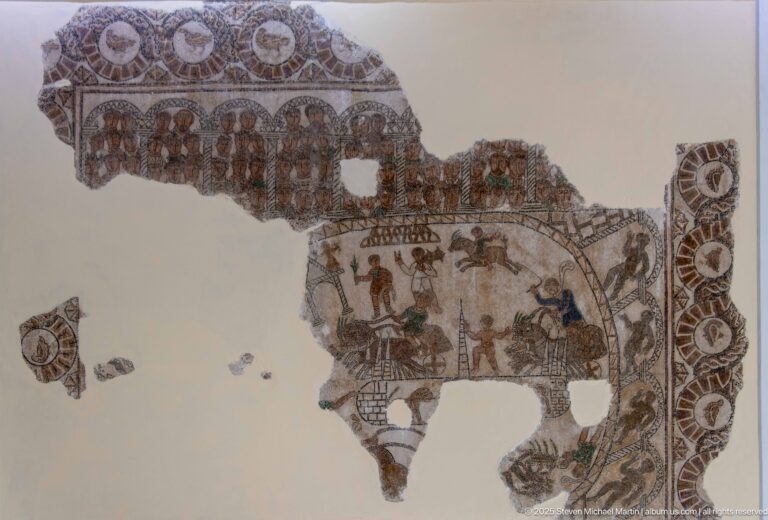 Fragmentary Roman mosaic with figures beneath an arcade, larger domestic or social scenes, and surviving circular border motifs.