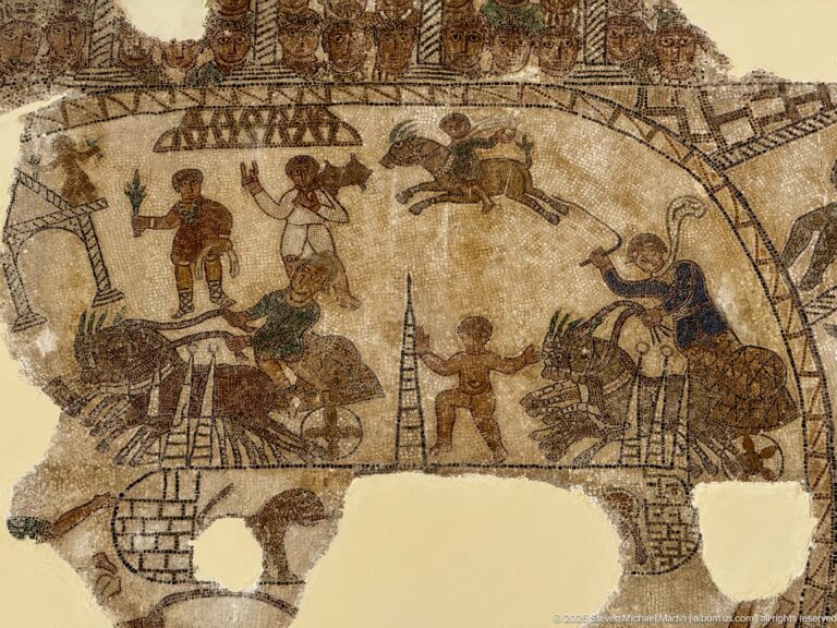 Roman mosaic arena scene with handlers or performers, large bovines, other animals, and curved architectural barriers.