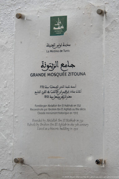 Multilingual wall plaque reading Grande Mosquée Zitouna with Arabic, French, and English historical text.