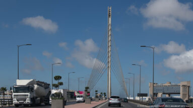 Traffic moves beneath a cable-stayed pylon and rows of streetlights on a broad Casablanca roadway.