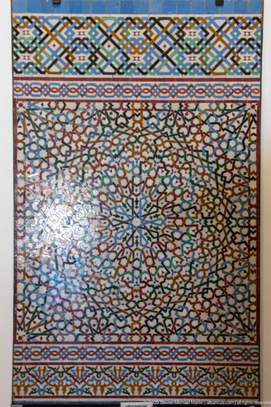 Rectangular multicolored zellij panel with dense radial geometry and patterned border bands.