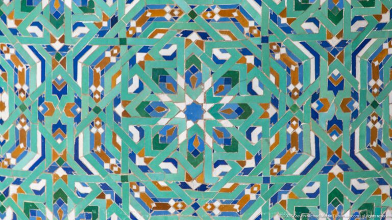 Close view of multicolored interlocking star and polygon mosaic patterns.
