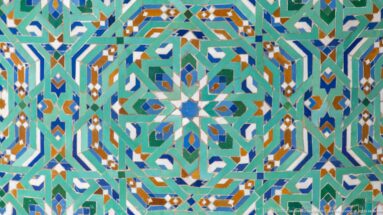 Close view of multicolored interlocking star and polygon mosaic patterns.
