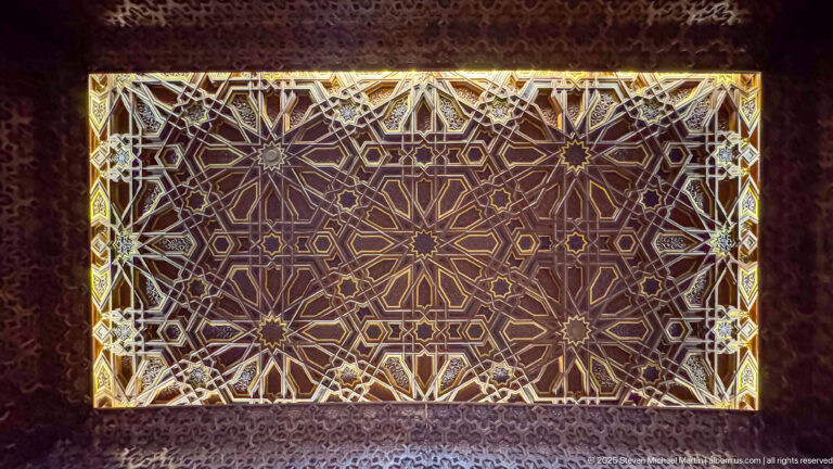Rectangular illuminated decorative panel filled with interlocking star polygons and geometric lattice patterns.